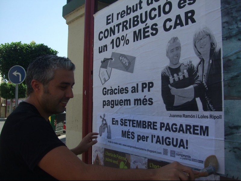 Juanma Ramon fixa un cartell informatiu sobre la taxa de l'aigua. C.X