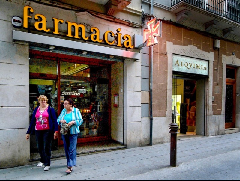 Dues dones passejant per davant d'una farmàcia de Girona JORDI SOLER FONT