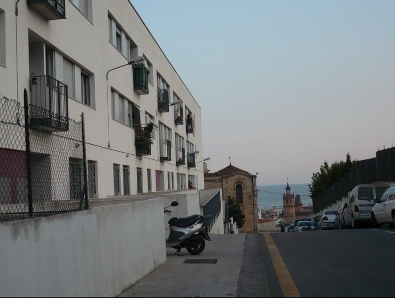 El bloc d'habitatges situat al Pla dels Frares amb la vista de l'església al fons. E.F
