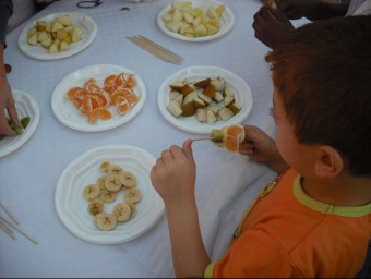 Un nen menjant fruita a Salt, en una imatge d'arxiu. EL PUNT AVUI