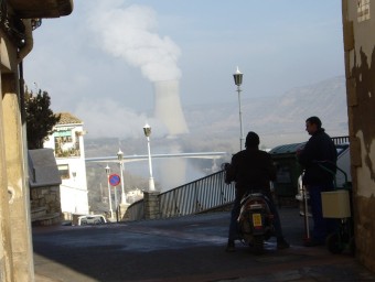 Un carrer d'Ascó amb la torre de refrigeració de la central nuclear al fons. ARXIU