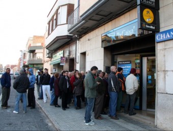 Cua d'afectats per la Cooperativa de l'Aldea davant les oficines de la Caixa, quest divendres al matí JORDI MARSAL /ACN