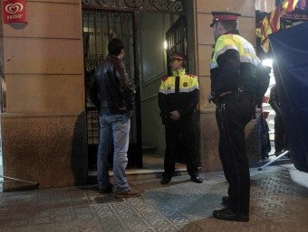 El portal del triple crim , situat al 287 del carrer Sardenya, ahir al vespre vigilat pels Mossos abans de l'arribada del servei judicial. EFE / ALBERTO ESTEVEZ