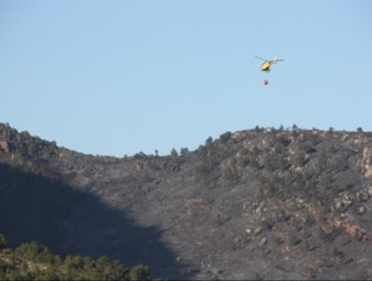 Un helicòpter dels Bombers sobrevola la zona de l'incendi, aquest dissabte a Mont-roig del Camp ACN