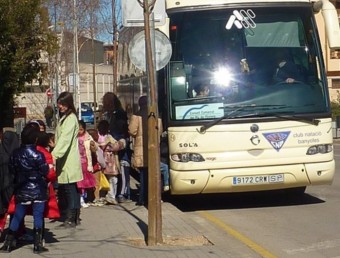 Alumnes pujant a un autobús escolar gestionat pel Consell Comarcal del Pla de l'Estany. R. E