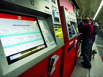 Usuaris del metro adquireixen un bitllet en una màquina. arxiu