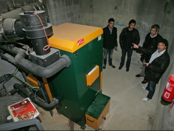 L'alcalde de Vilobí, Francesc Edo (a la dreta), acompanyat dels tècnics a la sala on hi ha la caldera de biomassa de la llar d'infants JUANMA RAMOS