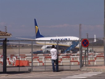 Una persona observant un avió de Ryanair parat a l'aeroport de Girona, dijous passat. O.M