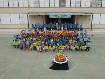 Una imatge del lipdub, amb els alumnes i mestres que van participar-hi, gairebé 240 persones, amb el pastis fet pels nens i nenes. EL PUNT AVUI