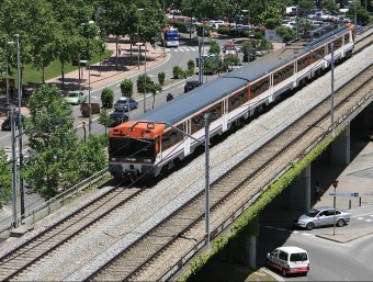 Un tren de rodalies circula pel viaducte del tren al seu pas per la rotonda del Rellotge de la Devesa MANEL LLADÓ