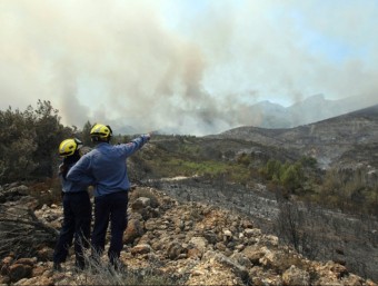 Dos bombers miren el fum que surt de l'incendi de Rasquera EFE