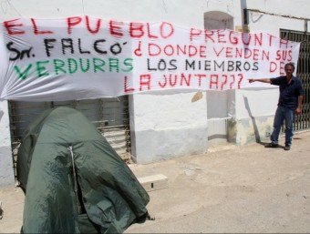 L'empresari mostra una pancarta amb la tenda de campanya parada al costat JORDI MARSAL / ACN