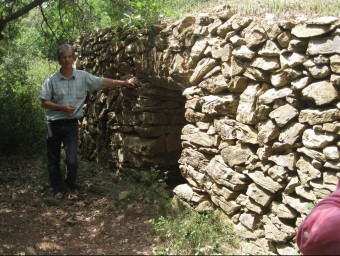 Jenar Felix, explicant les característiques de les barraques de pedra seca en una visita comentada a la Garrigad'Empordà E. C