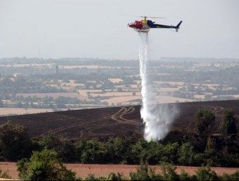 Un helicòpter dels bombers remullava ahir la zona cremada a causa de l'incendi dels Prats de Rei L. BUSQUETS / ACN