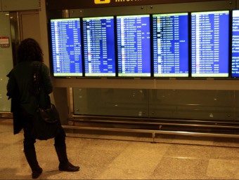 Una dona mira els panells a l'aeroport del Prat ALBERT SALAMÉ / ARXIU