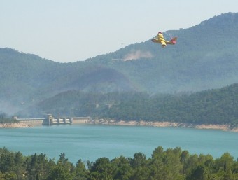 Un hidroavió que participa en les tasques d'extinció del foc, sobrevola aquest dimarts el Pantà de Boadella