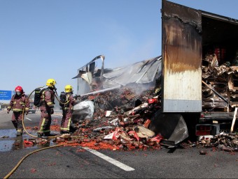 Els bombers apagant ahir les flames al remolc del camió que es va incendiar a l'altura del punt quilomètric 72,5, a Riudellots de la Selva JOAN SABATER