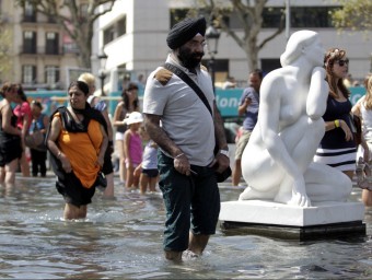 Turistes i barcelonins es remullaven ahir a les fonts de la plaça Catalunya EFE