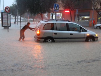 Una dona empeny un vehicle atrapat per les inundacions l'avinguda Barcelona de Tortosa ACN