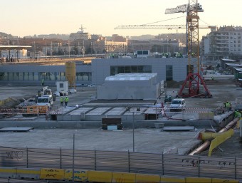 Imatge exterior de l'estació del TAV de Girona, amb treballadors ultimant-ne els detalls LLUÍS SERRAT