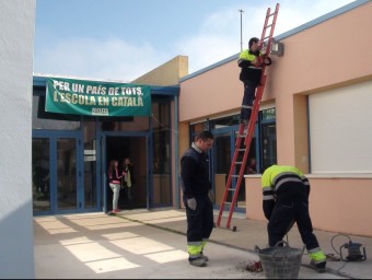 Operaris traient les faroles i instal·lant les noves a l'escola Forn d'Anells de Fornells de la Selva EL PUNT AVUI