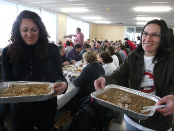Dues voluntàries a punt de servir safates d'arròs ahir al pavelló de Bàscara. LLUÍS SERRAT