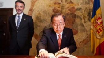Ban Ki-moon signa el llibre de visites de la Casa de la Vall, seu del Consell General d'Andorra, el parlament andorrà, observat de prop pel Síndic General, Vicenç Mateu Zamora. EDUARD COMELLAS / CONSELL GENERAL D'ANDORRA
