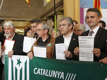 Representants dels ajuntaments barcelonins mostren l'ingrés, a l'esquerra. A la dreta, els gironins presentant documentació M. PÉREZ / M. SABRIÀ