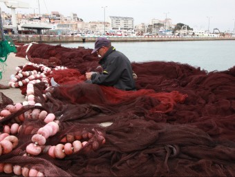 Un pescador reparant xarxes ahir a la tarda al moll de Palamós, en la darrera setmana de veda de la gamba JOAN SABATER