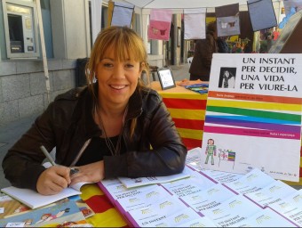 Núria Jiménez, signant exemplars del llibre durant la diada de Sant Jordi. EL PUNT AVUI