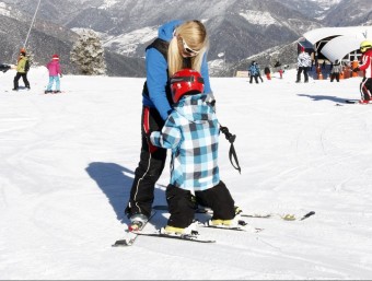 Monitora d'esquí amb un petit alumne a l'estació de Portainé a l'inici de la temporada.  ACN