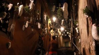 Dos visitants, ahir a la nit al Barri Vell de Girona. El muntatge floral correspon al carrer Miquel Oliva, a prop del plaça del Correu Vell JOAN SABATER
