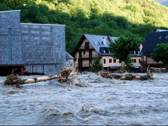 Troncs arrossegats pel riu Garona al seu pas de Vielha, ben a prop de les cases ACN