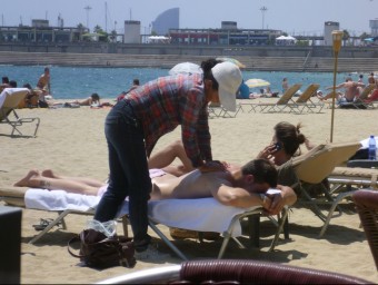 Una dona xinesa fa un massatge il·legal en una platja de Barcelona. X. AGUILAR