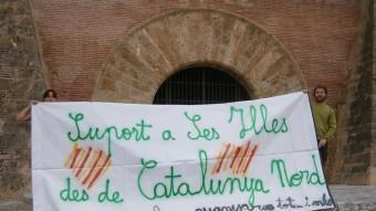 Pancarta desplegada davant la porta principal d'accés al Palau dels Reis de Mallorca de Perpinyà EL PUNT