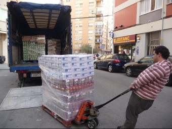 Un voluntari de la fundació Adra a Badalona, fotografiats dimarts, quan va arribar a l'entitat menjar de la Unió Europea. S.M