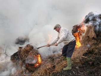 El pagès apagant les flames al paller de Can Sala de Riudarenes. JOAN CASTRO (ICONNA)