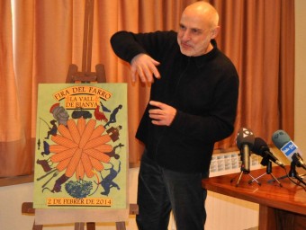 L'artista Quim Domene, amb el cartell de la Fira del Farro d'aquest any, durant la presentació. J.C