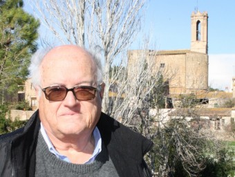 Joan Badia i Homs, a Parlavà, amb l'església de Sant Feliu al fons.  JOAN PUNTÍ
