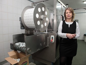 Núria Morell davant d'una de les màquines envasadores de micropastilles de mantega.  JOAN SABATER