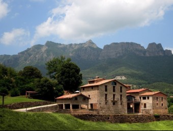 Una vista del mas amb el Pugsacalm i Santa Magdalena al fons.