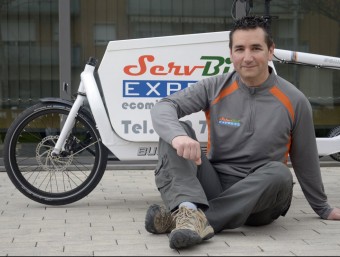 Joan Admetlla, amb la bicicleta que utilitza per fer el transport de paquets.  JUDIT TORRES