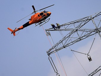 L'helicòpter acosta el cable als dos operaris, que el passen per una de les politges M. LLADÓ