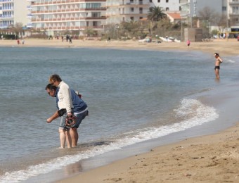 El bon temps de l'abril ha fet que la gent s'acostés a la platja, a remullar-se els peus i, els més agosarats, a banyar-se JOAN CASTRO/ICONNA