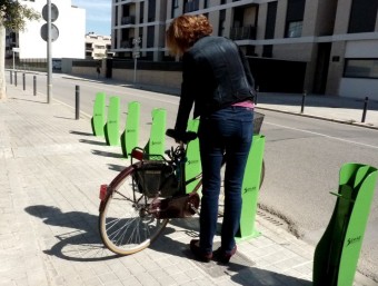 Una usuària mirant de col·locar la seva bicicleta en l'aparcament del carrer Llibertat. R. E