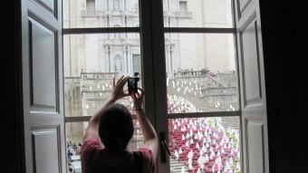 Una noia fa una foto amb el mòbil de les escales de la Catedral des d'una finestra de la Casa Pastors DANI VILÀ