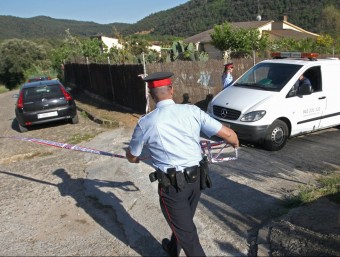 Els Mossos aixequen el cordó policial per donar pas al furgó funerari que transporta el cos de la víctima cap a l'institut de medecina legal. LLUÍS SERRAT