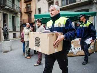 La policia local d'Olot en el moment d'enretirar les urnes a la capital de la Garrotxa.  Martí Albesa