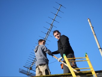 Dos instal·ladors adaptant l'antena el 2010 arran de l'apagada analògica. LLUÍS SERRAT