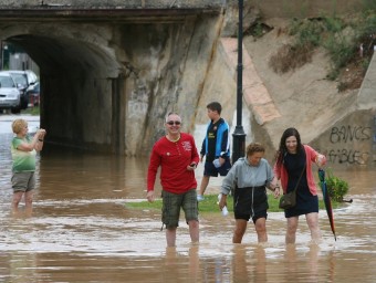 Diverses persones travessen una carretera inundada, aquest dilluns a Altafulla EFE